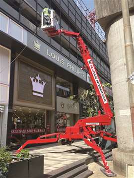 A RentEase spider lift in operation on a high street